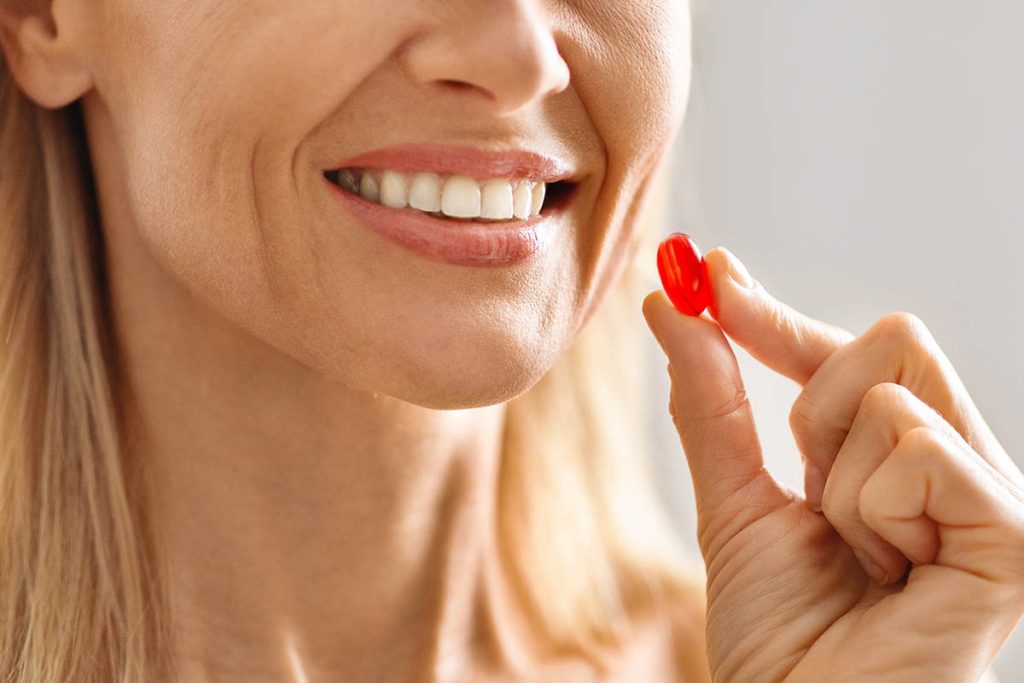 Closeup Shot Of Smiling Middle Aged Woman Taking Vitamin Pill Capsule