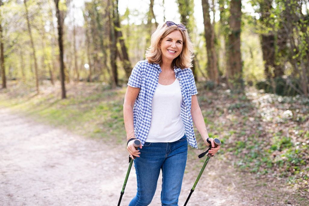 Older woman smiling hiking outdoors summer