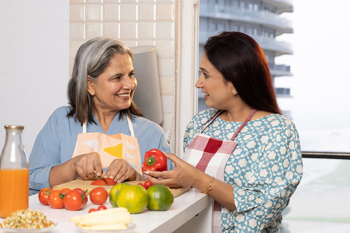 Young and older women sitting with healthy food and fresh drinks