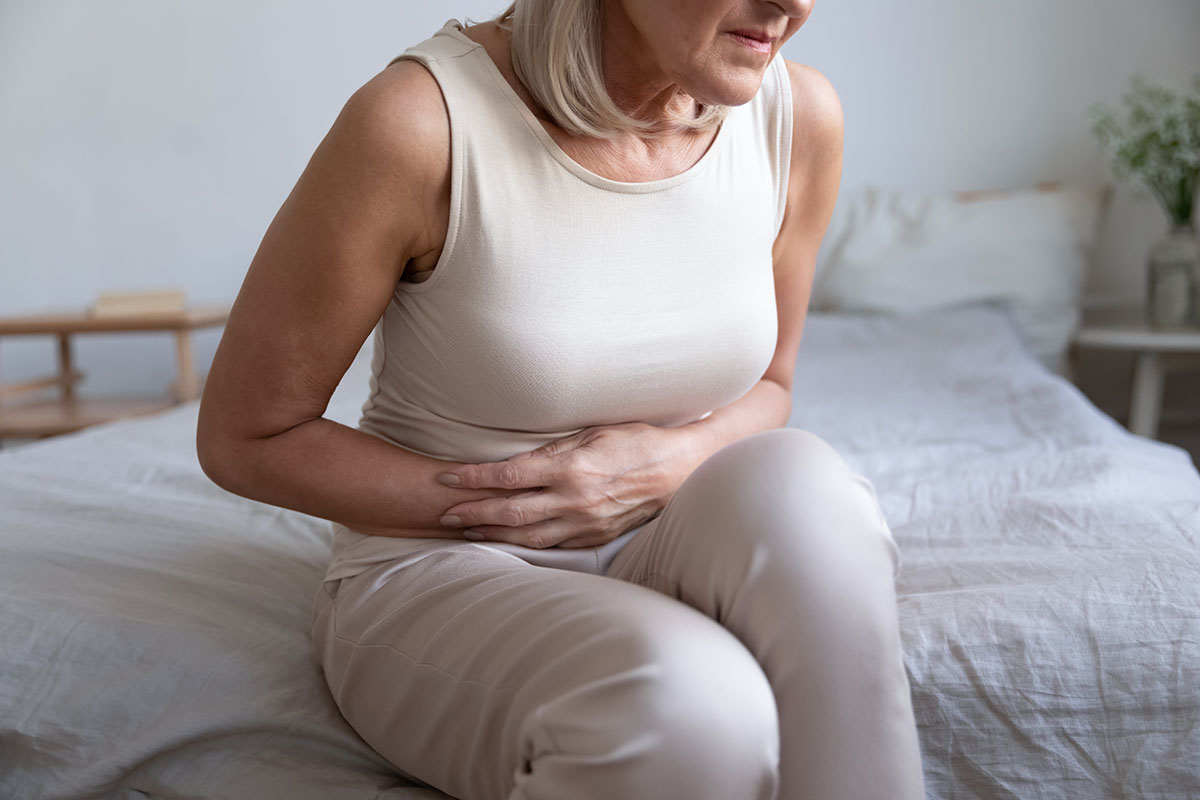 Cropped image older unhealthy woman embracing belly, suffering from strong stomach ache.
