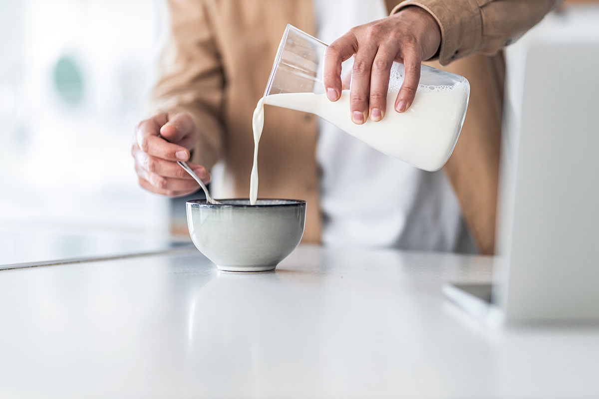 man pouring milk in a bowl