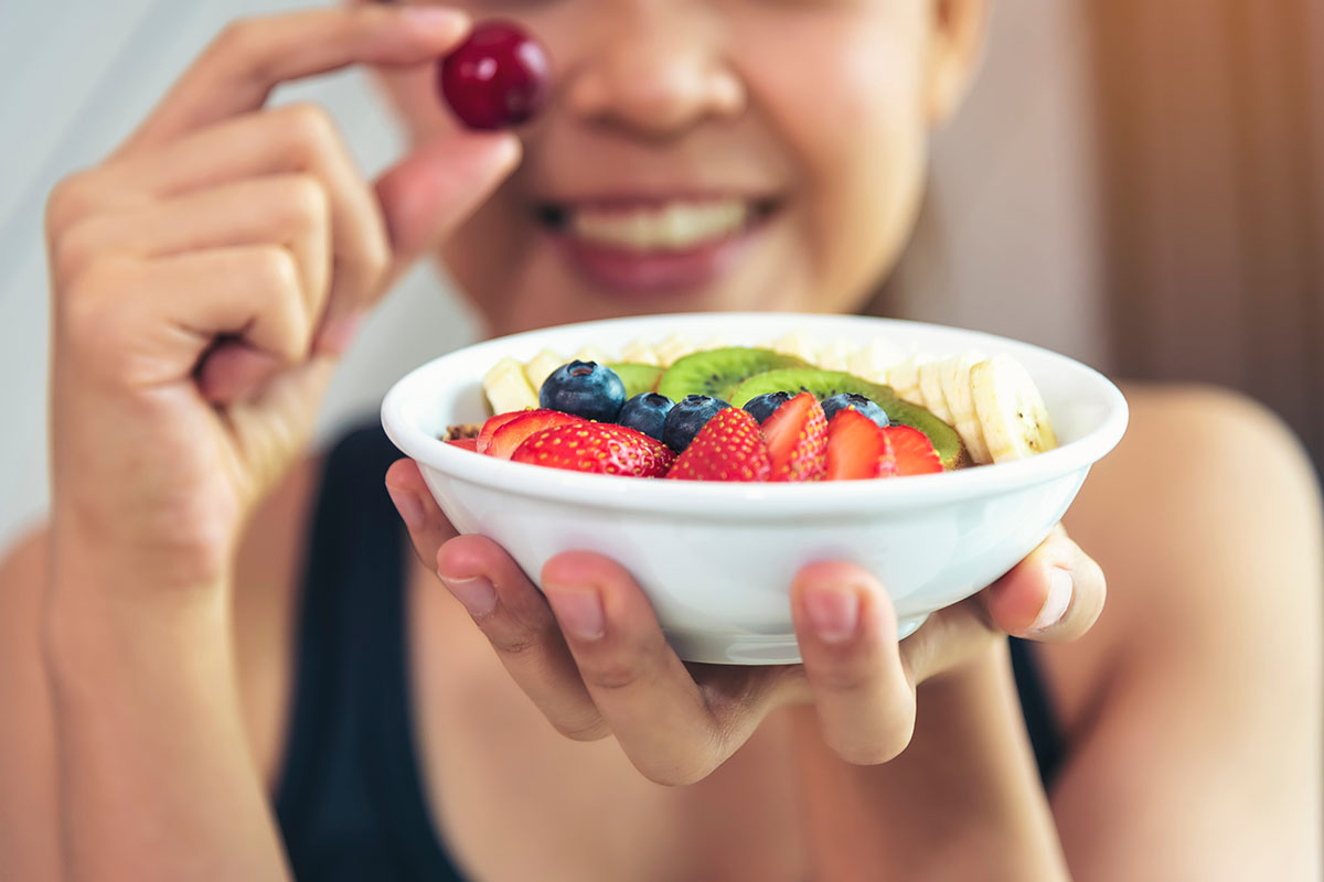 Woman holding bowl of fruit