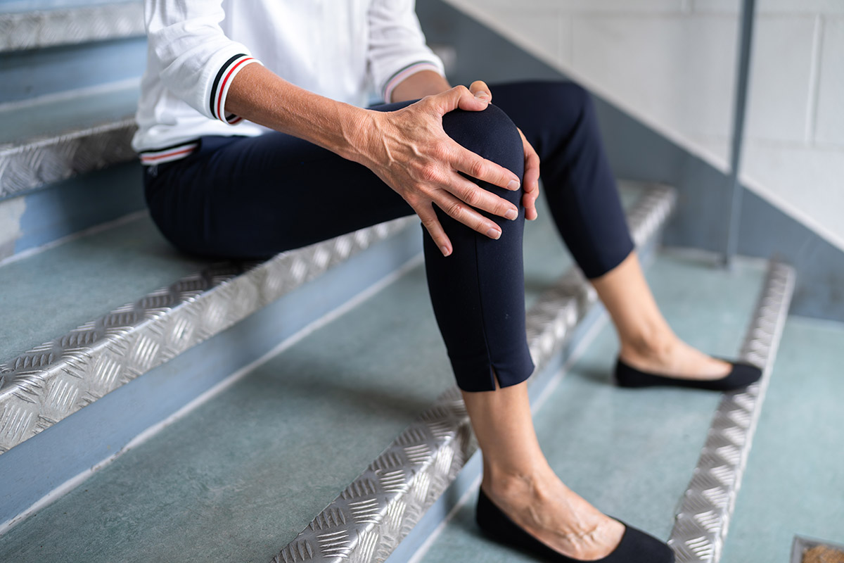 Mature Woman Sitting On Staircase After Slip And Fall Accident