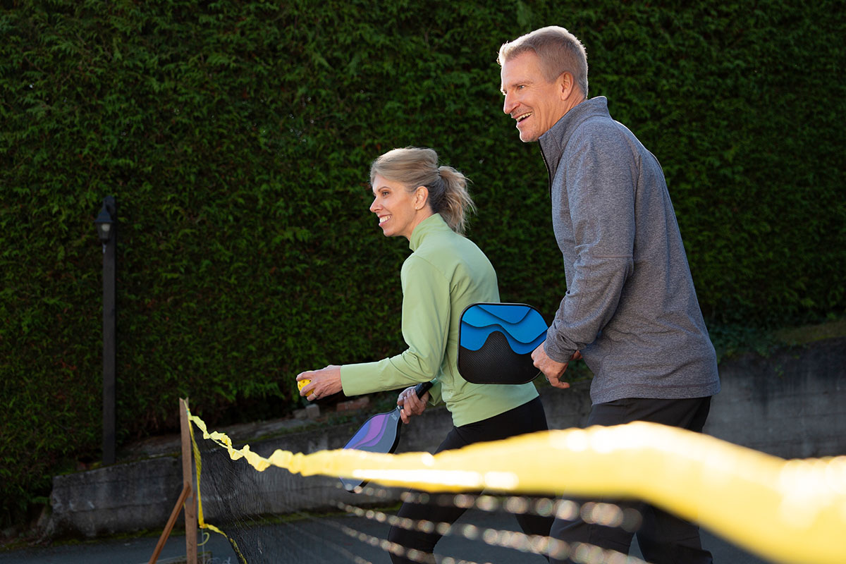 Fit older couple playing pickleball