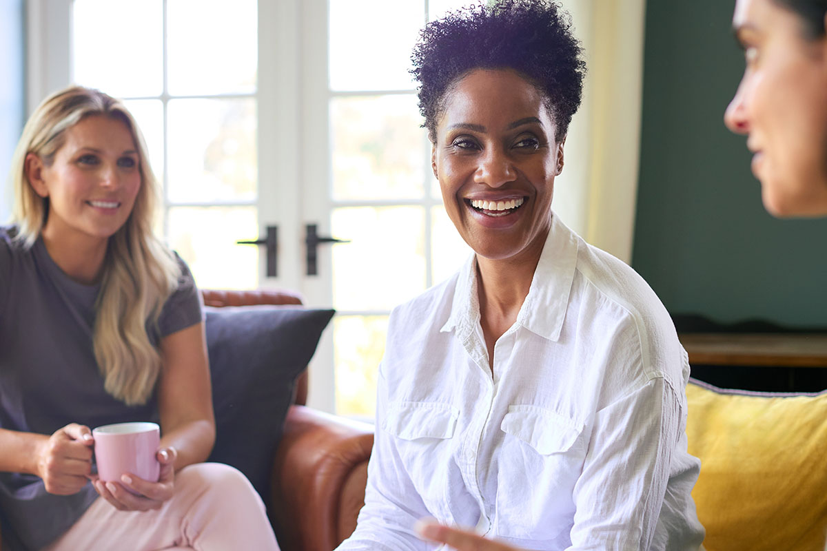 Three Mature Female Friends In Lounge At Home Meeting For A Chat