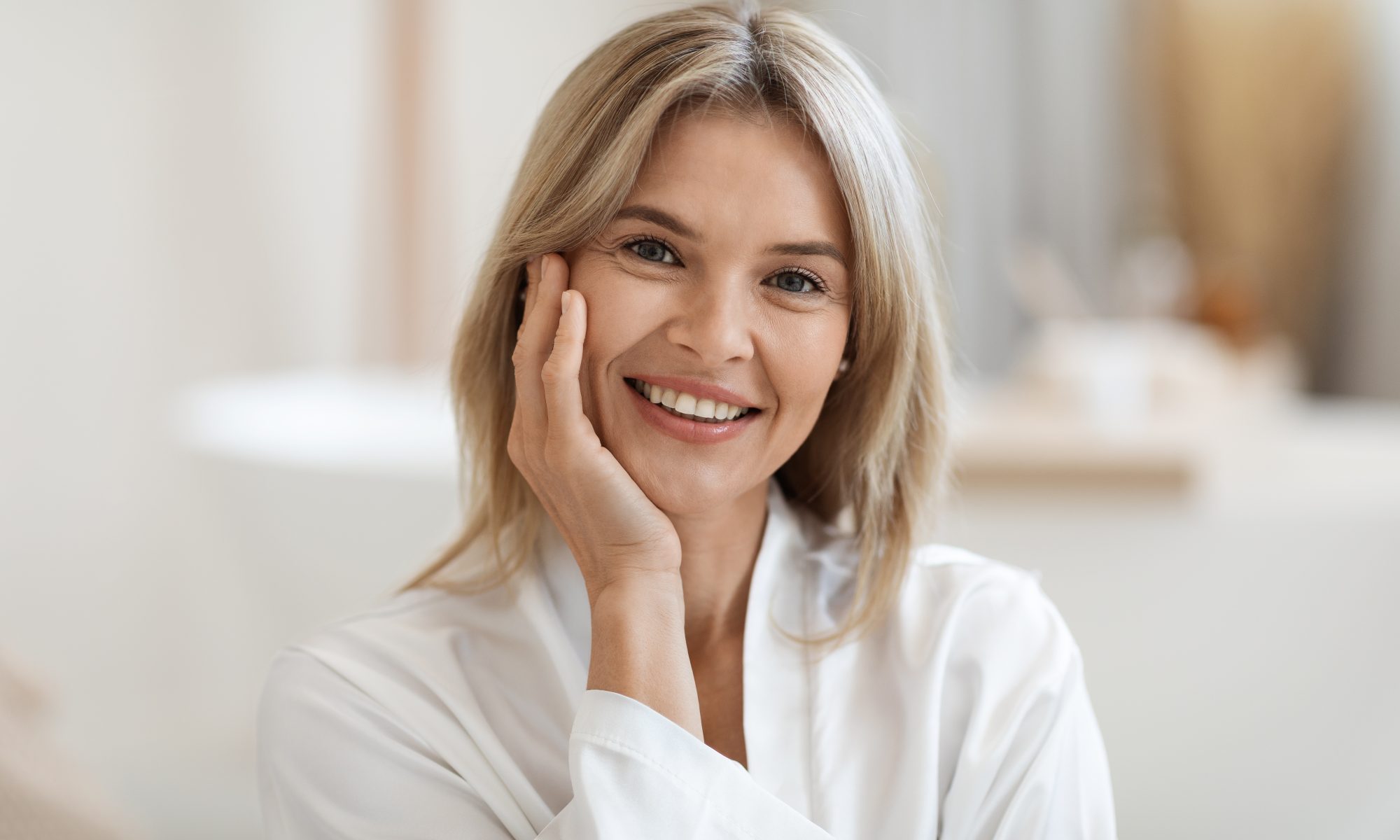 Portrait of smiling middle age woman touching her face