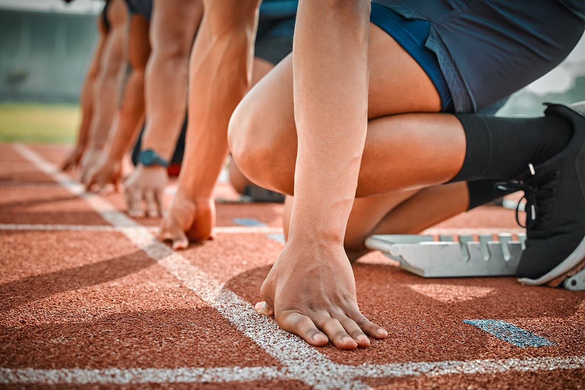 Race, start and hands of men on track at arena for speed challenge, marathon event and sports. Ready, set and group of people at competition lines for fitness, exercise and running athlete at stadium