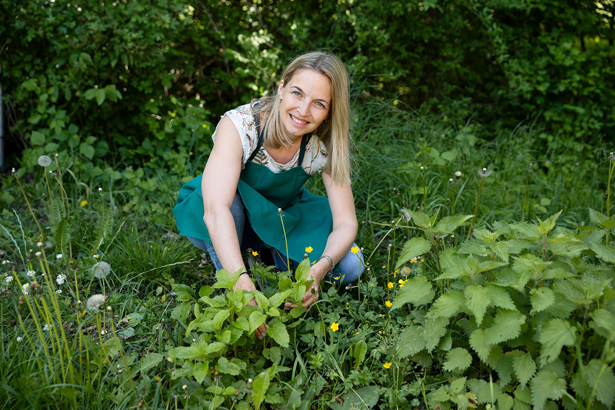 woman in her early 40s, collects wild herbs in the garden