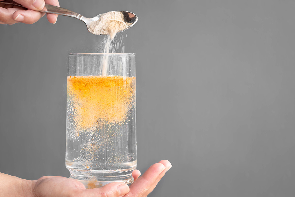 Orange fizzy powder and water glass 